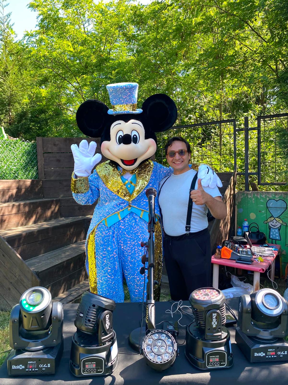 Açık hava etkinlik alanında Mickey maskotu ve sahne ekipmanları